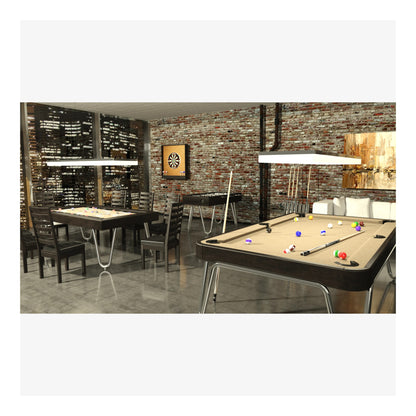 Billiards table with pool cues and balls in a room with brick wall and cityscape window.