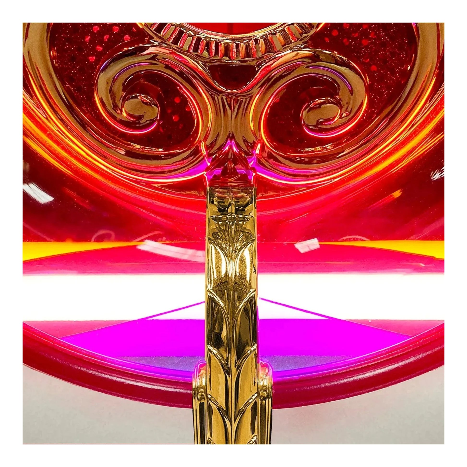 Decorative object with gold and red design on a white background