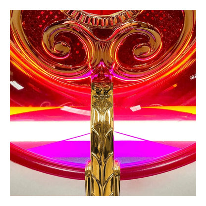 Decorative object with gold and red design on a white background