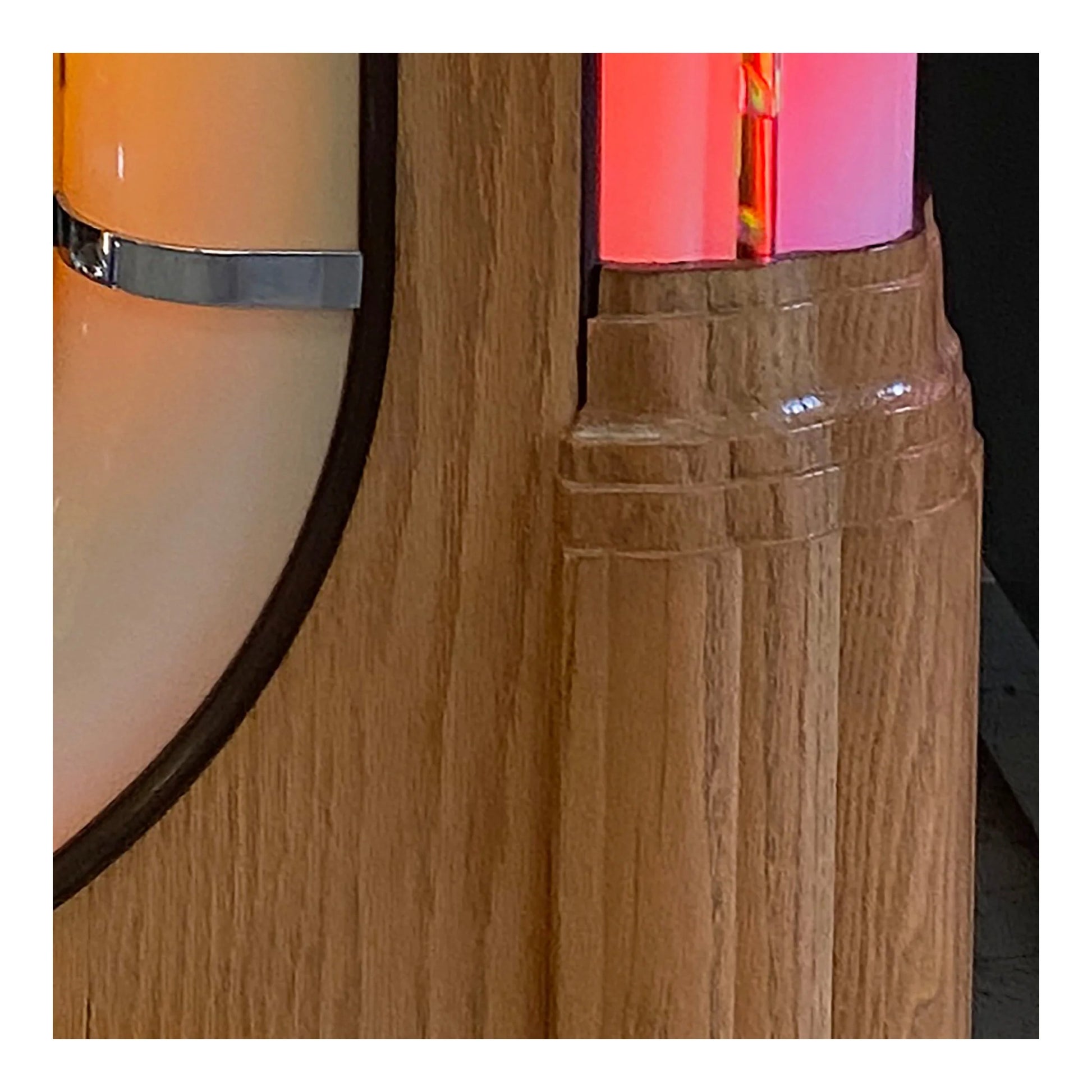 Close-up of a wooden surface with a metallic ring and colorful object in the background