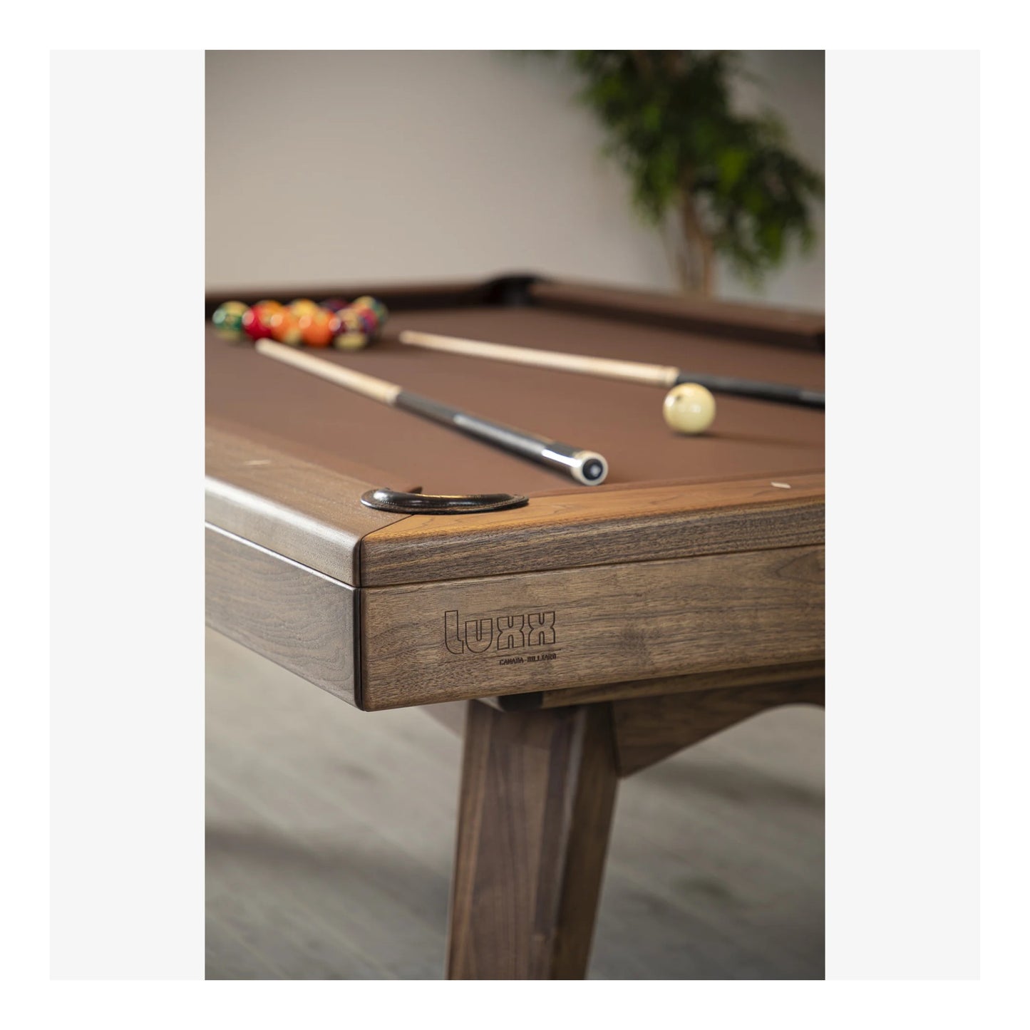 Wooden pool table with cues and balls on a light background