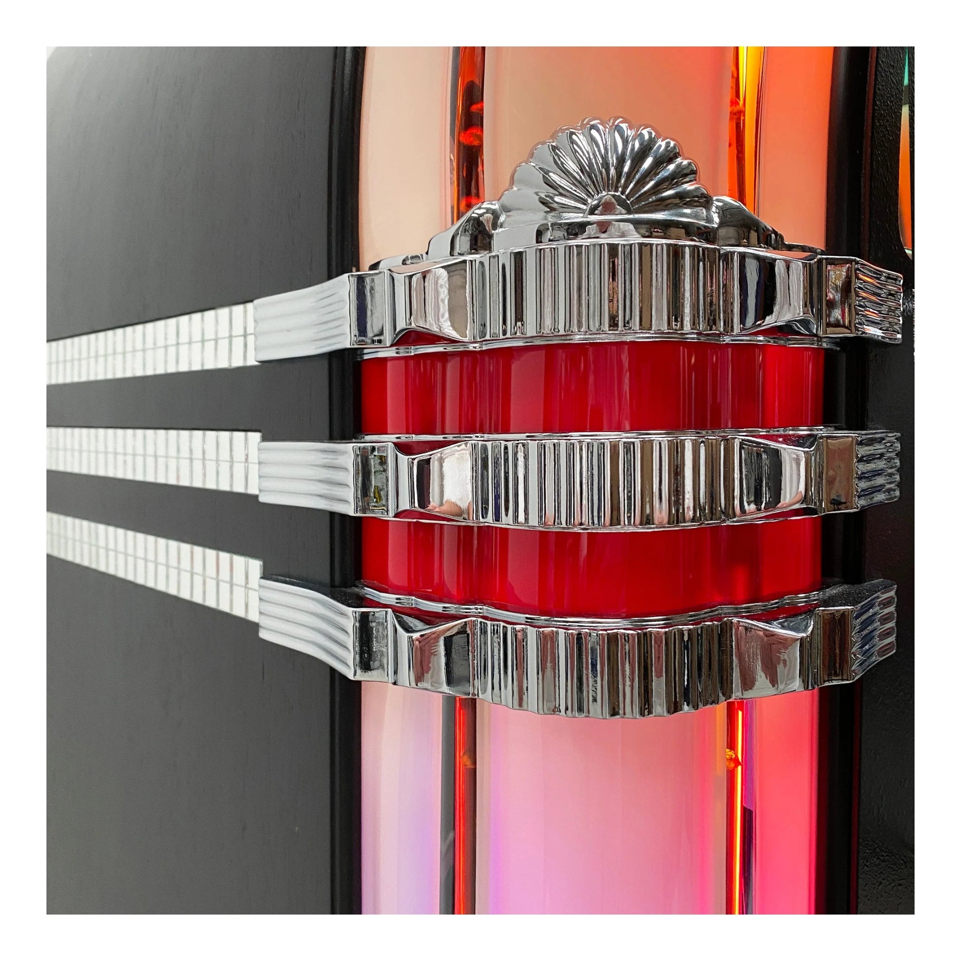 Decorative wall piece with red central element and silver accents on a black background