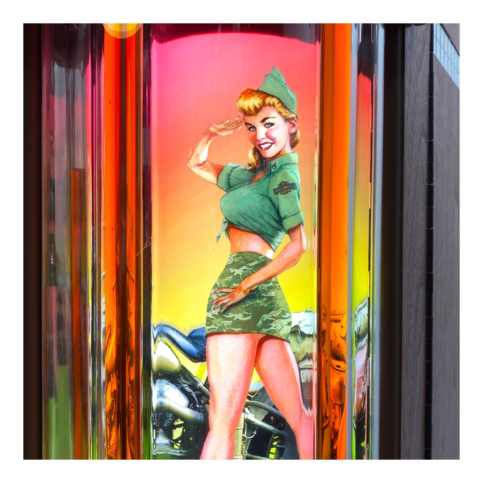 Vintage-style poster of a woman in a green outfit with a motorcycle on a colorful background