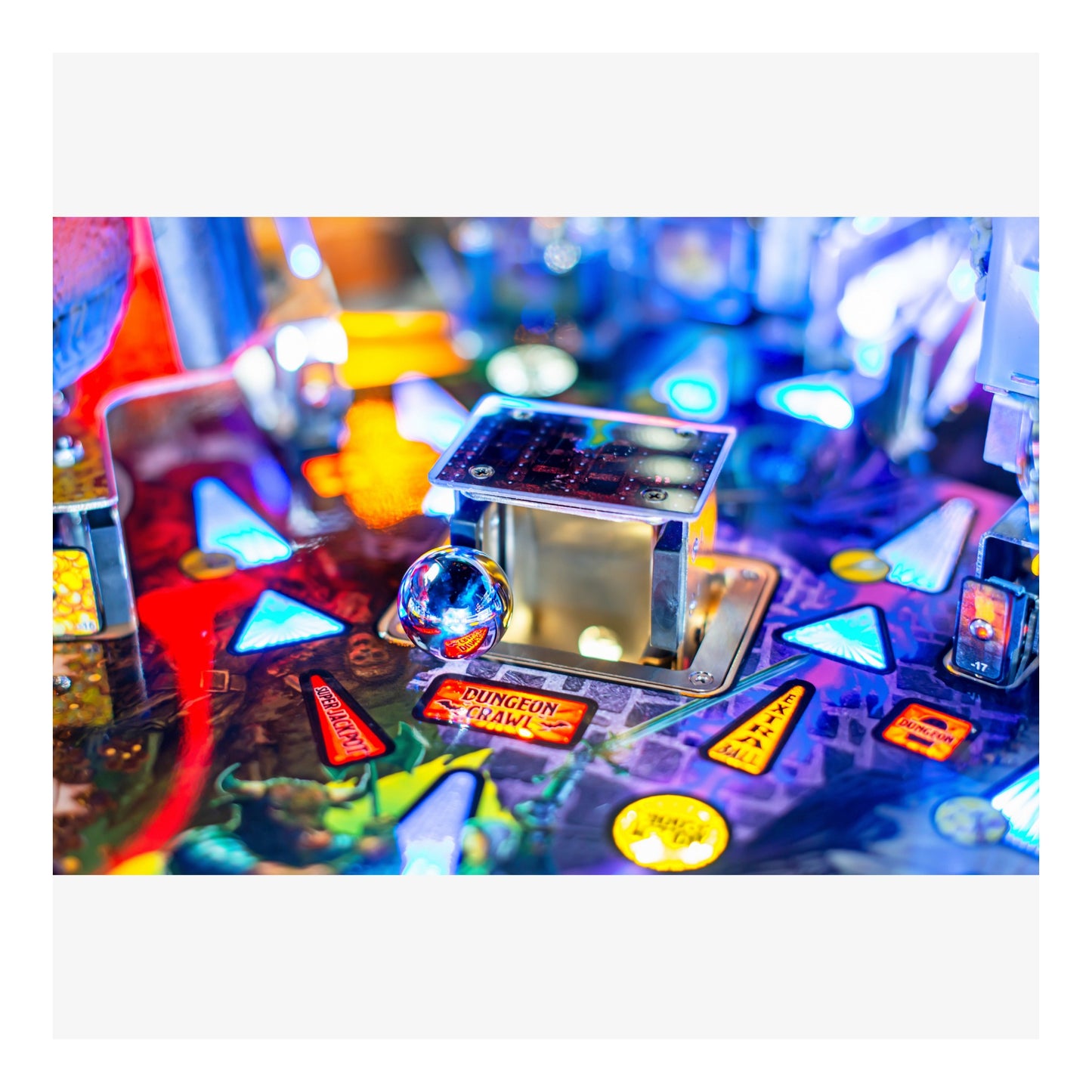 Close-up of a pinball machine with colorful playfield and various components.