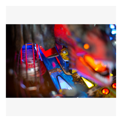 Close-up of a colorful pinball machine with bright lights and mechanical parts.