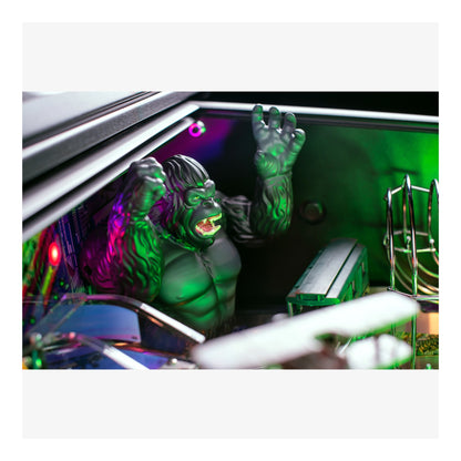 Close-up of a green monster toy inside a computer case with colorful lighting.