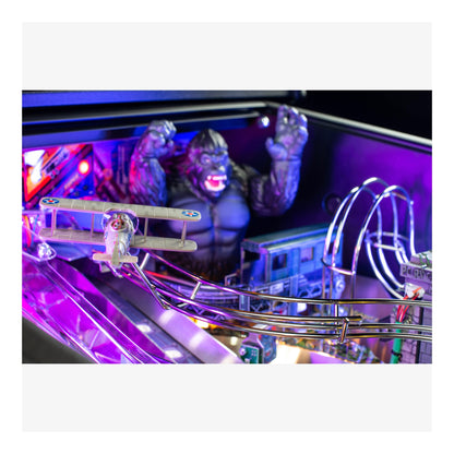 Close-up of a pinball machine with a purple glow, featuring a character and game elements.