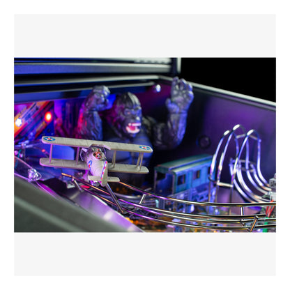 Close-up of a pinball machine with glowing lights and figures.