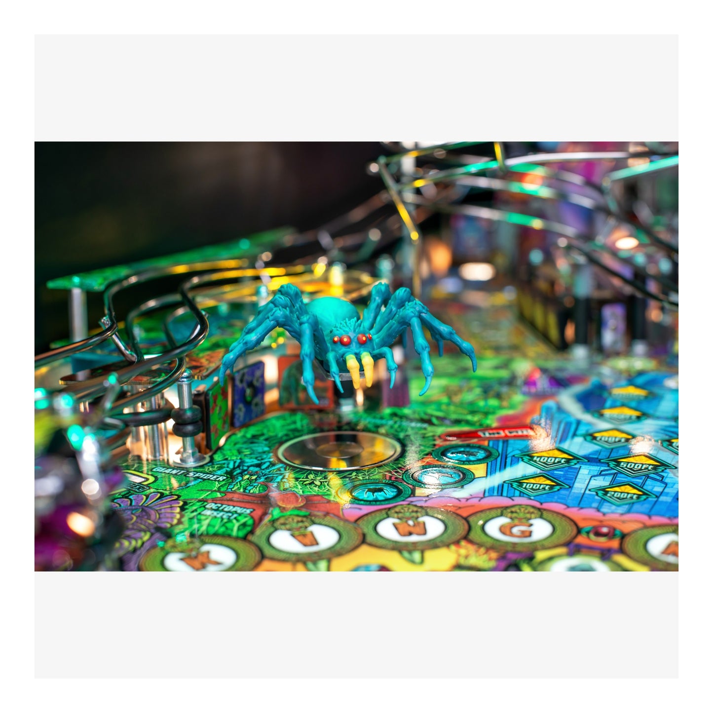 Colorful pinball machine with a blue spider figure on a white background