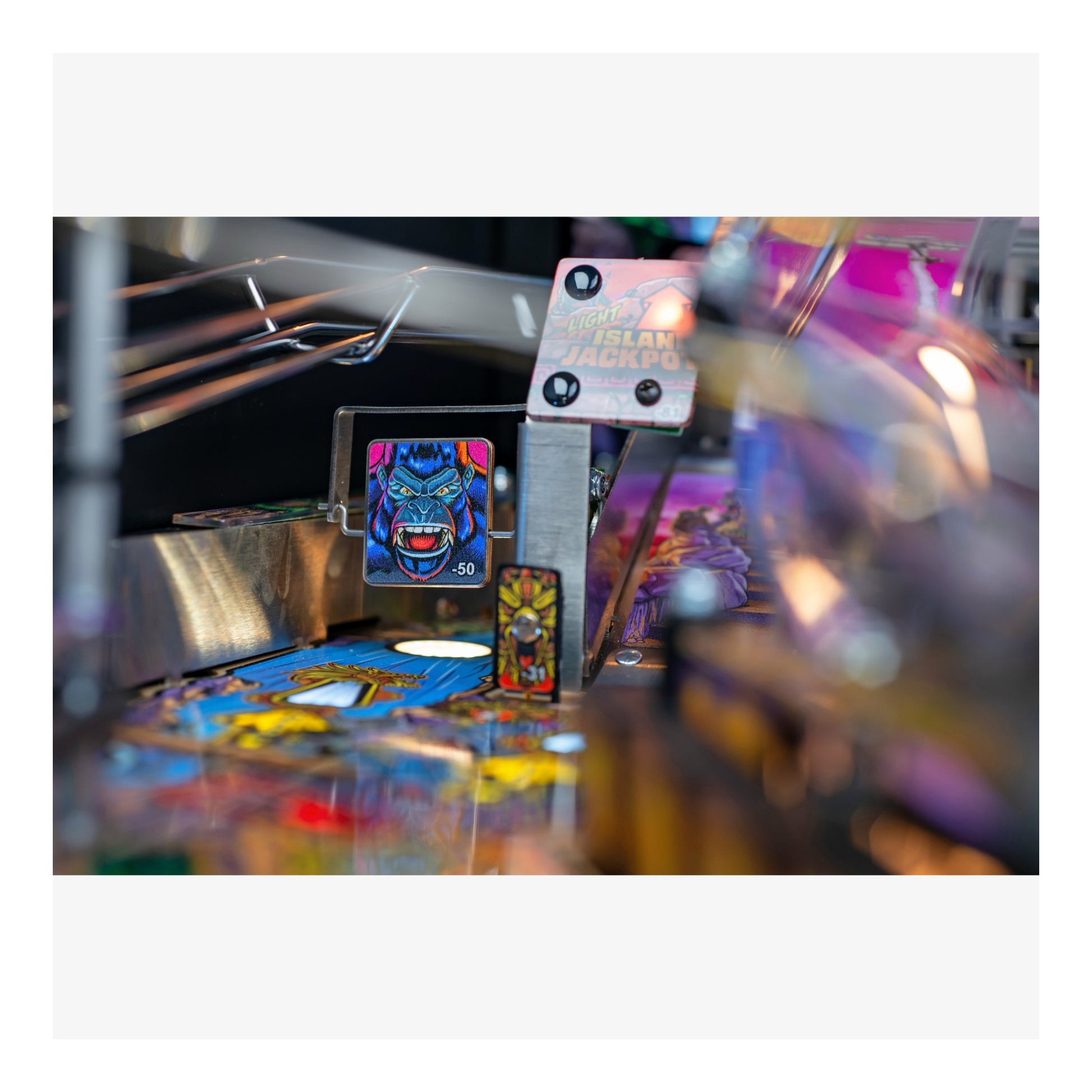 Close-up of a pinball machine with colorful artwork and lights.