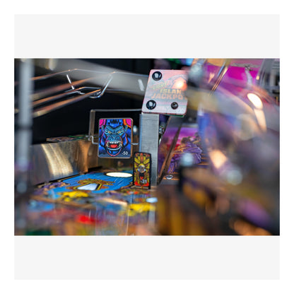 Close-up of a pinball machine with colorful artwork and lights.