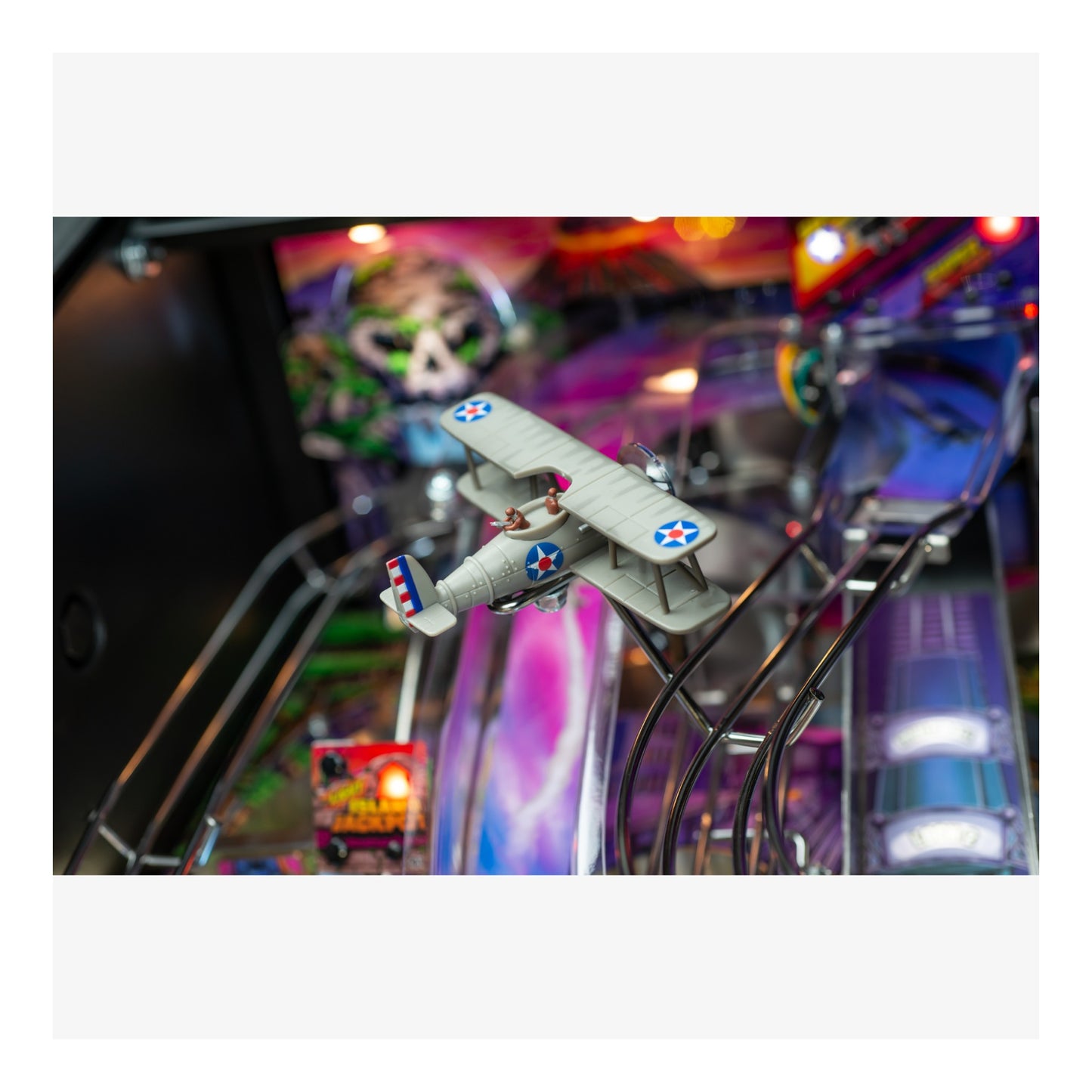 Pinball machine with a biplane figure and colorful background