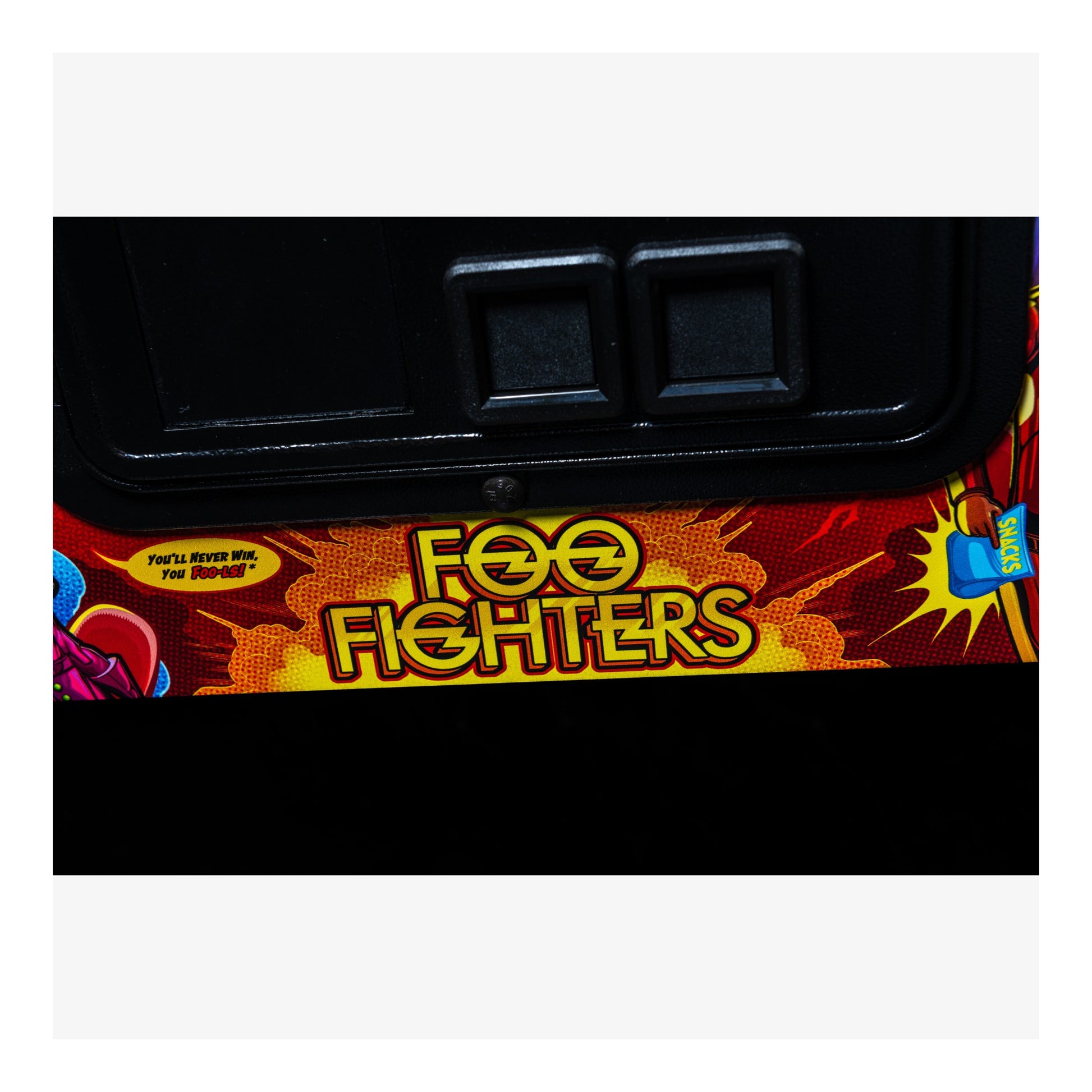 Close-up of a 'Foo Fighters' arcade cabinet with colorful graphics and text.
