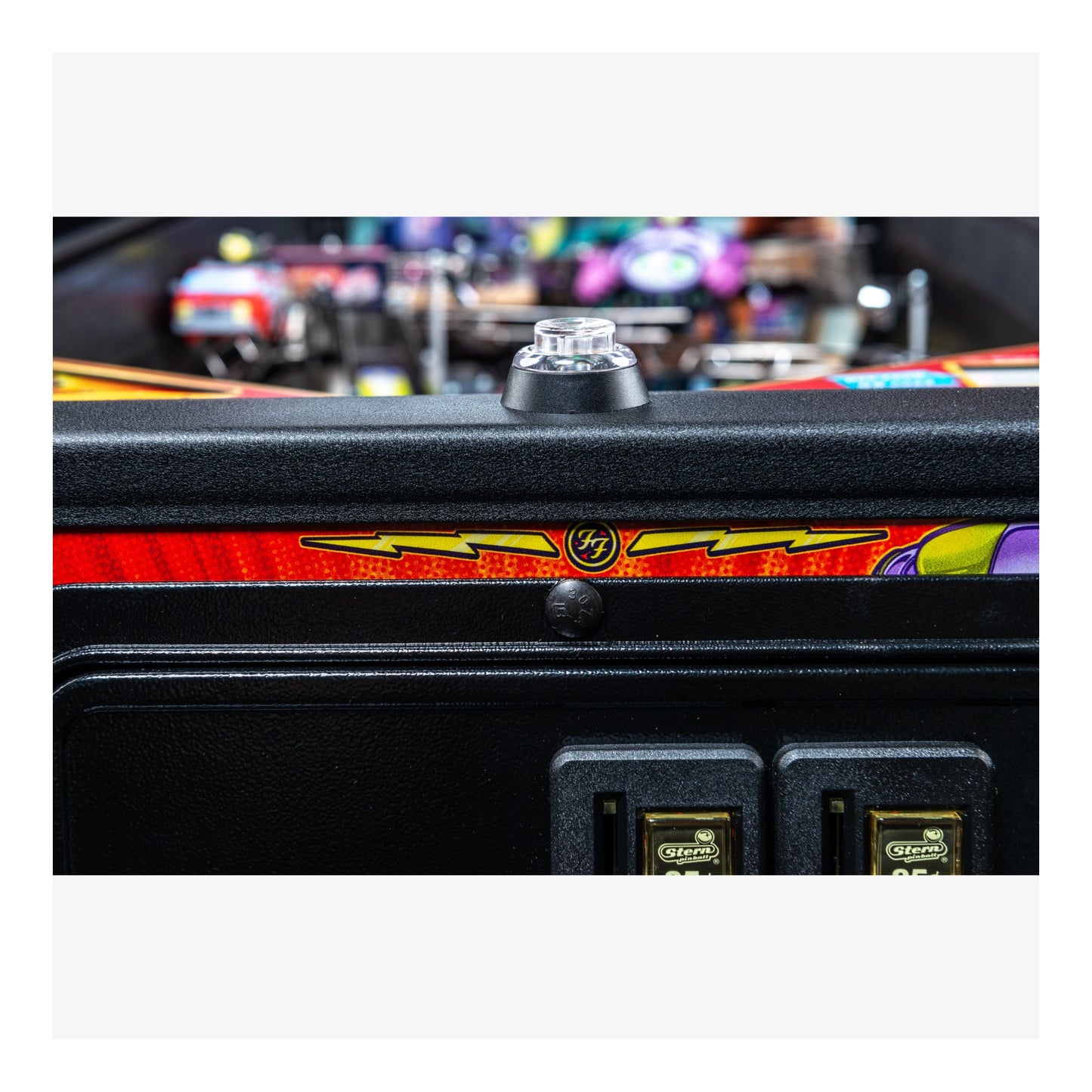 Close-up of a pinball machine with colorful marquee and control panel.