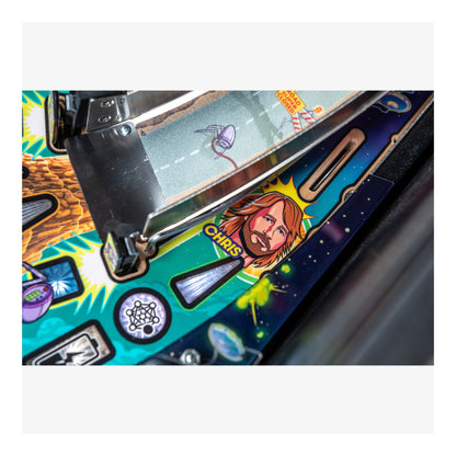 Close-up of a colorful pinball machine with a character illustration and text.