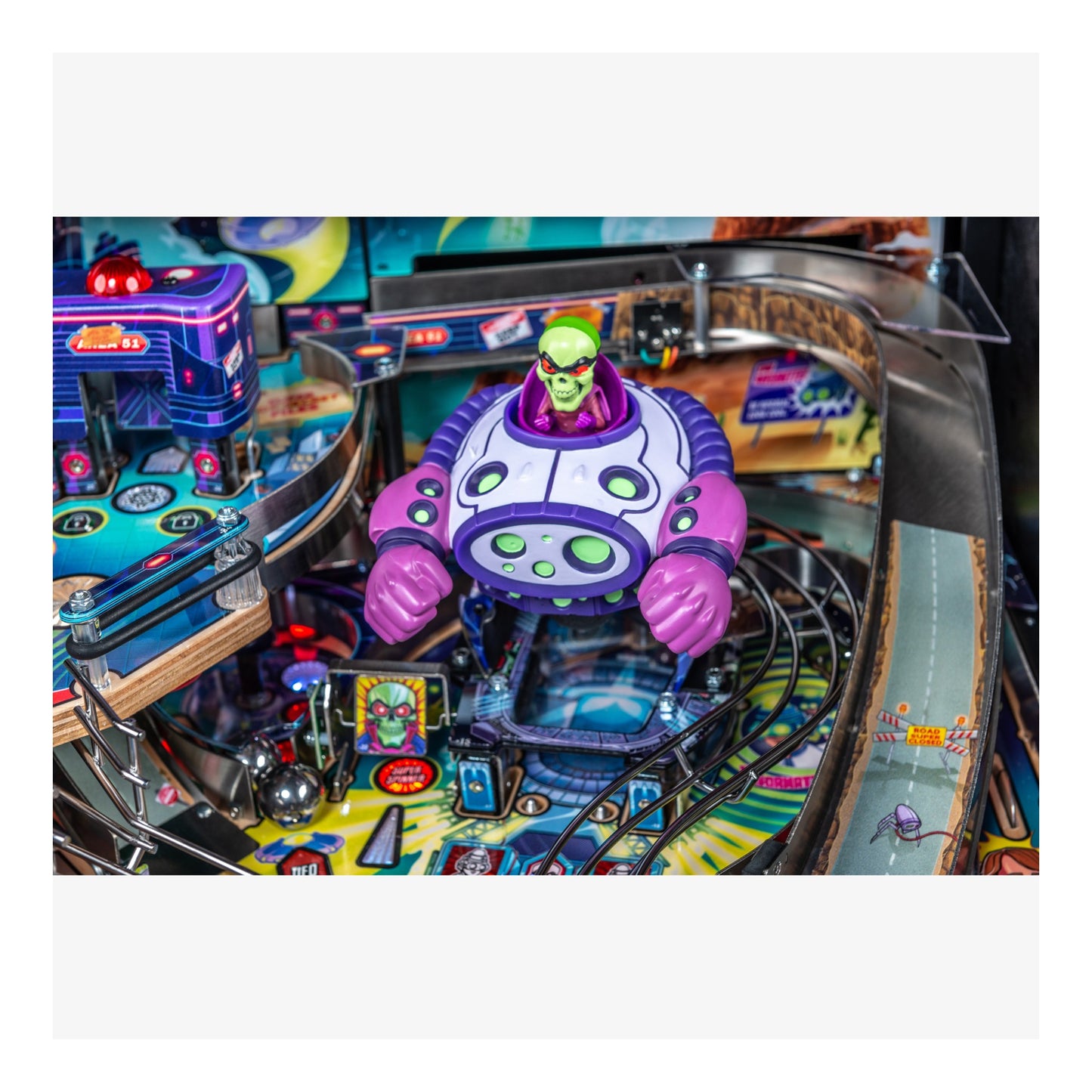 Pinball machine with a colorful alien figure on the playfield