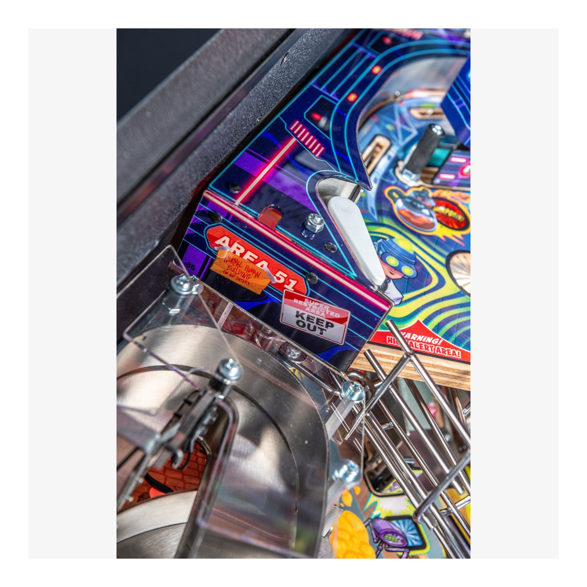 Close-up of a pinball machine with colorful artwork and metallic components.