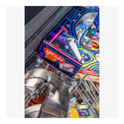 Close-up of a pinball machine with colorful artwork and metallic components.