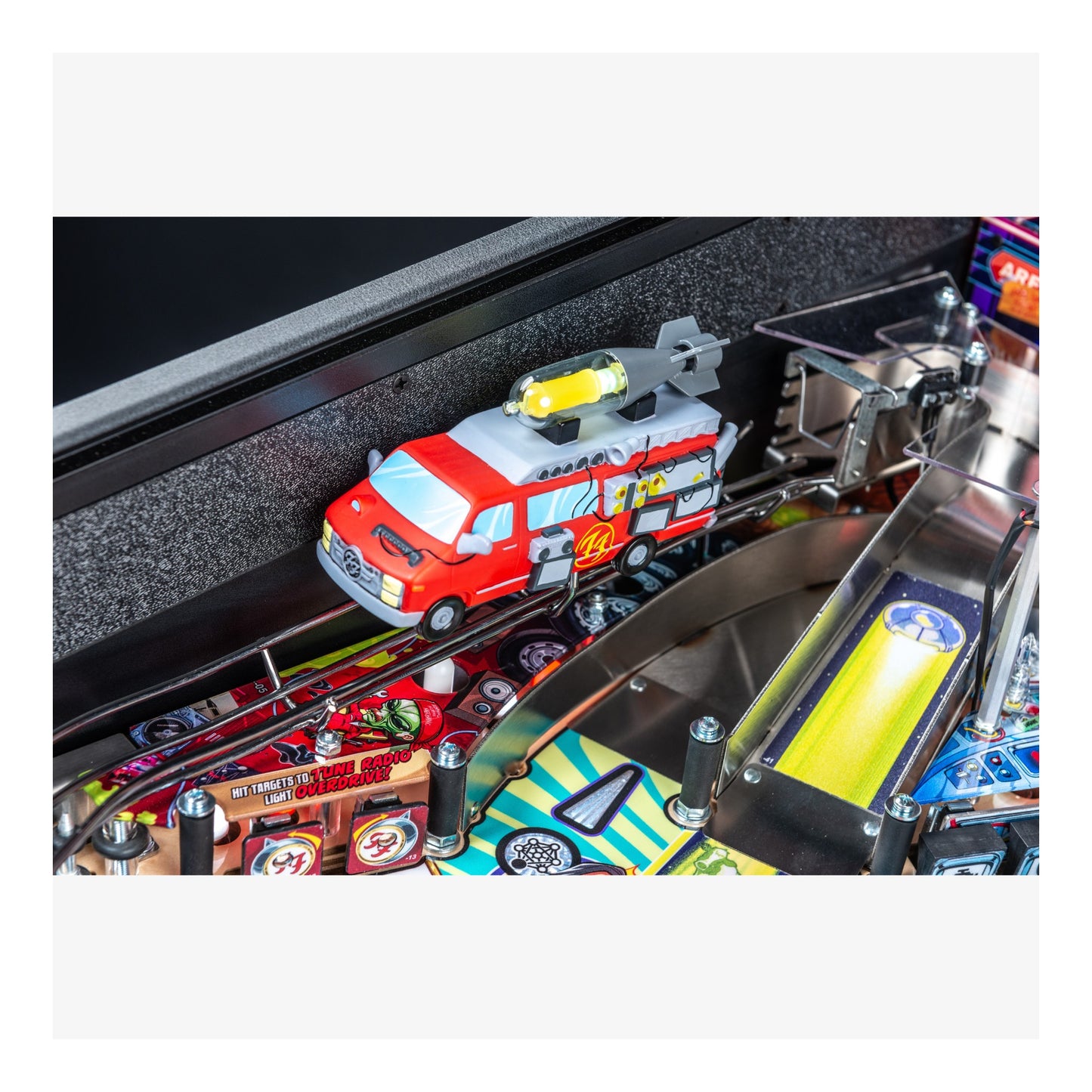 Toy fire truck on a pinball machine track with various game components.
