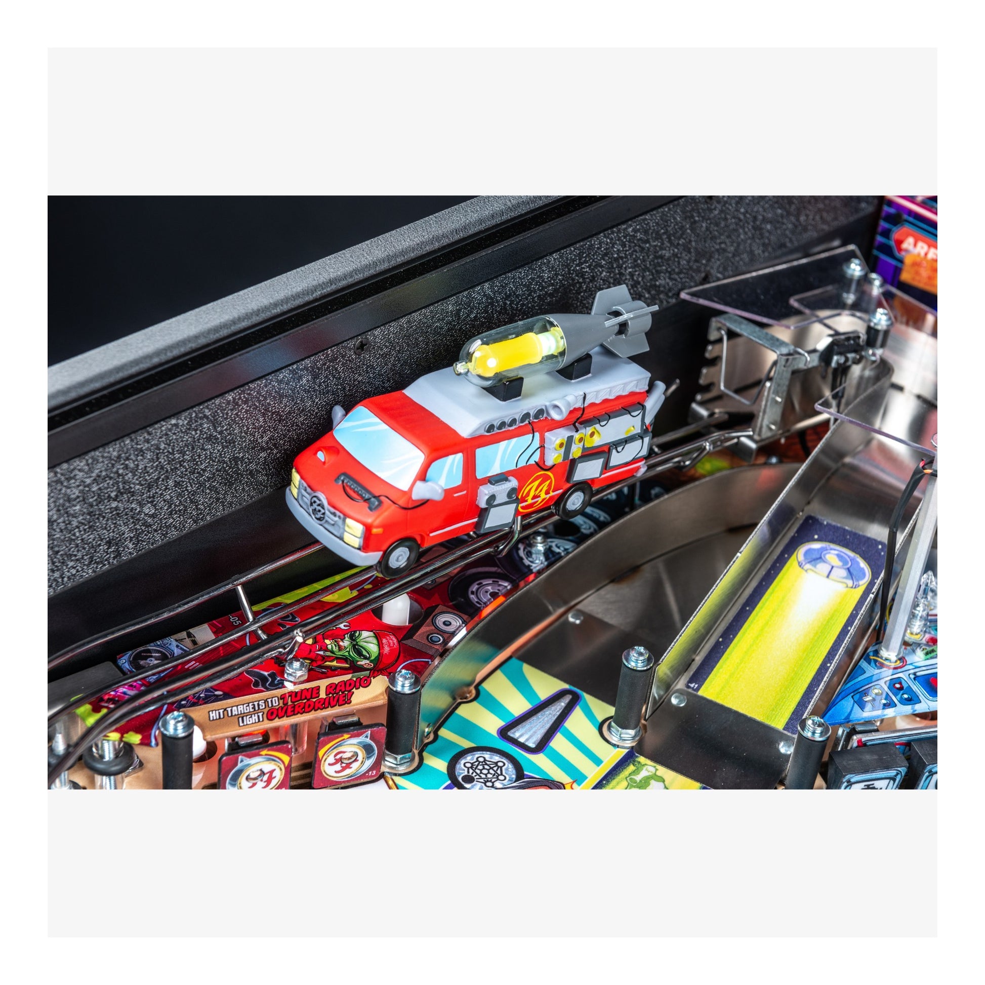 Toy fire truck on a pinball machine track with various game components.