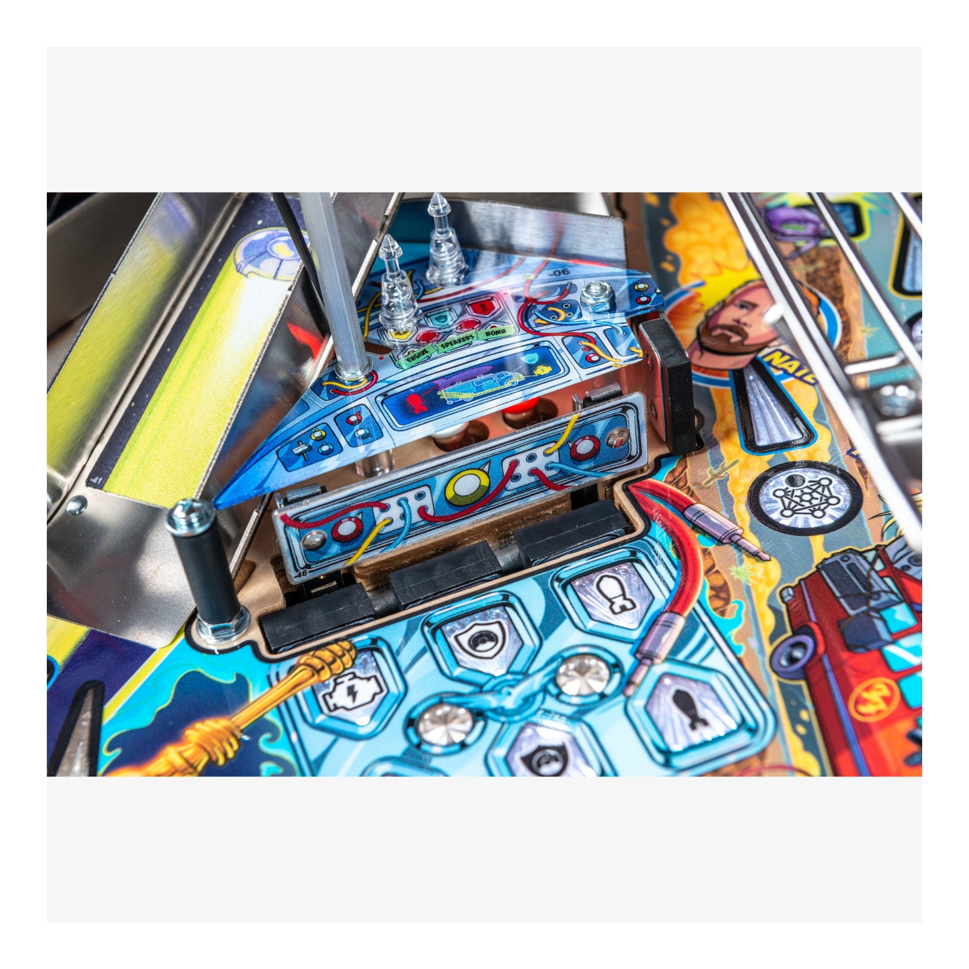 Close-up of a colorful pinball machine with various components and artwork.