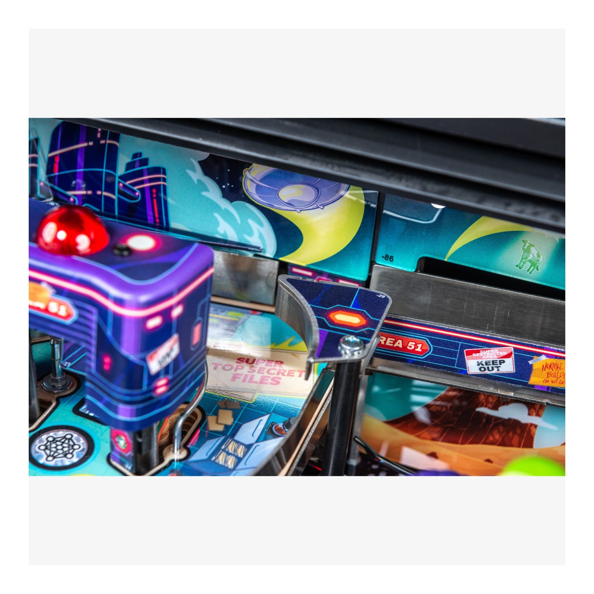 Close-up of a pinball machine with colorful artwork and a joystick.