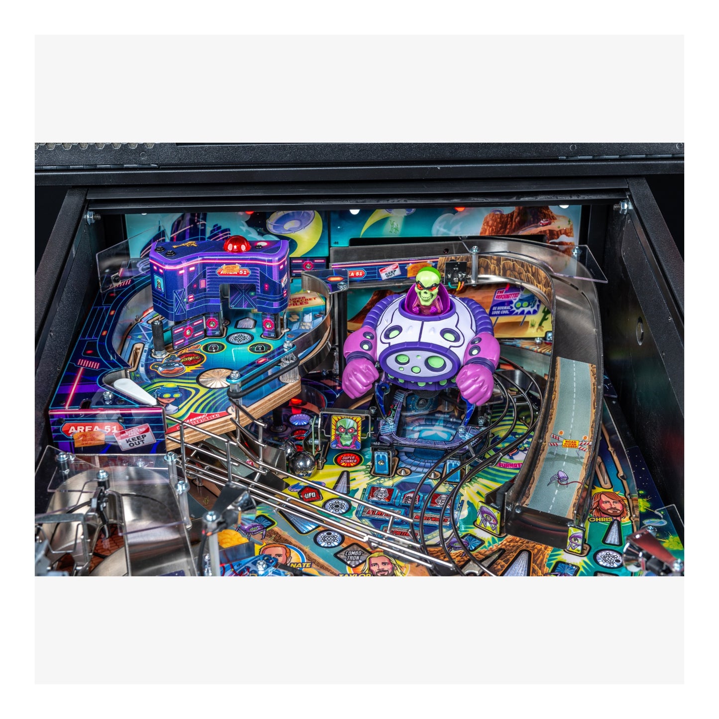 Colorful pinball machine with vibrant graphics and a purple character figure.