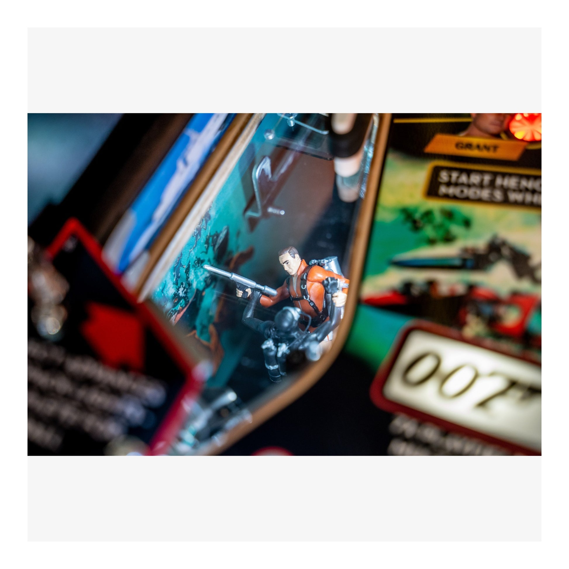 Close-up of a James Bond 007 pinball machine with a player in action.