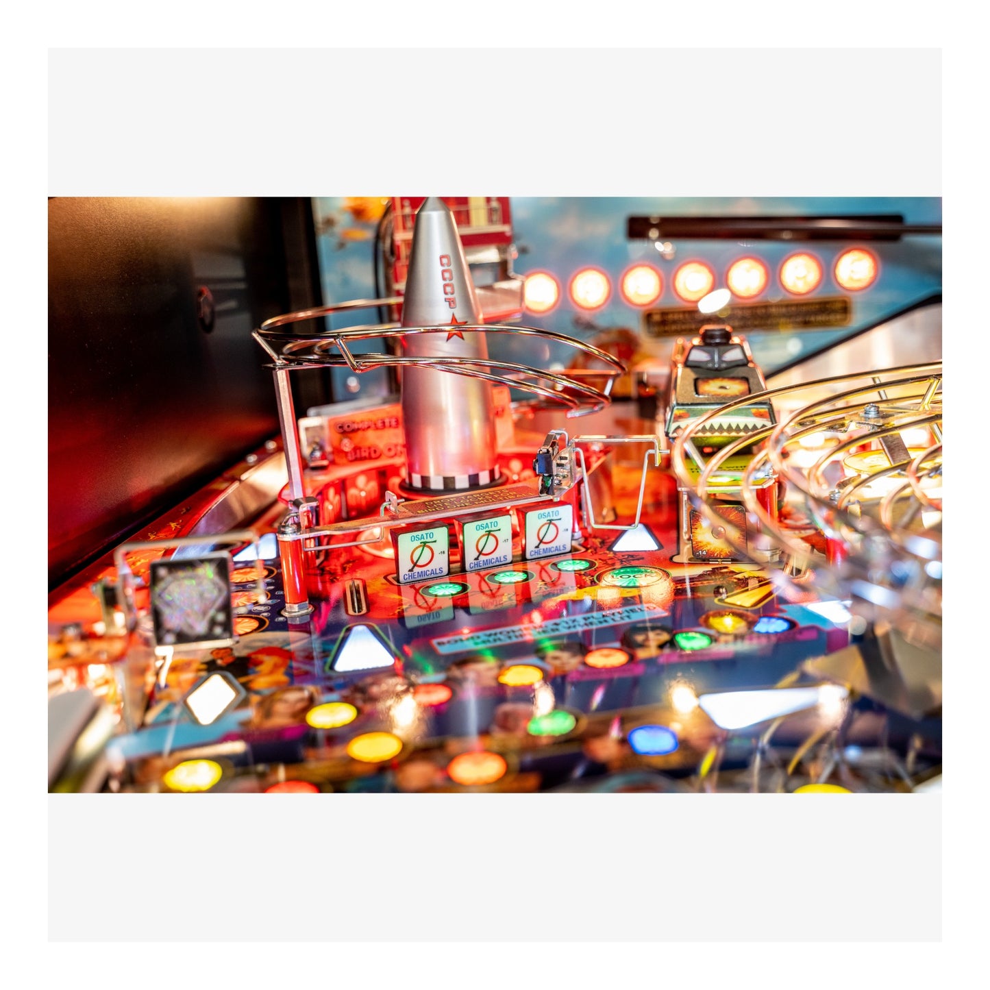 Close-up of a pinball machine with colorful lights and components.