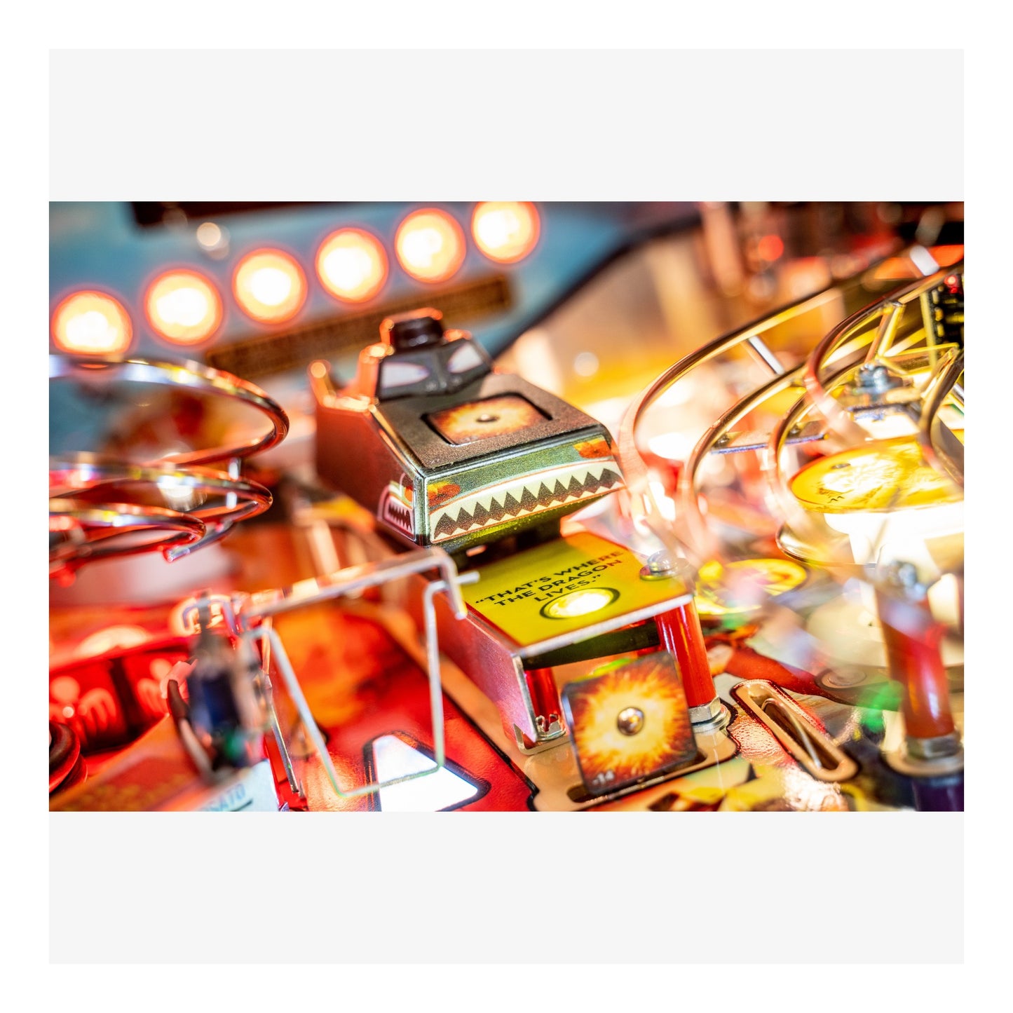 Close-up of a pinball machine with colorful lights and components.