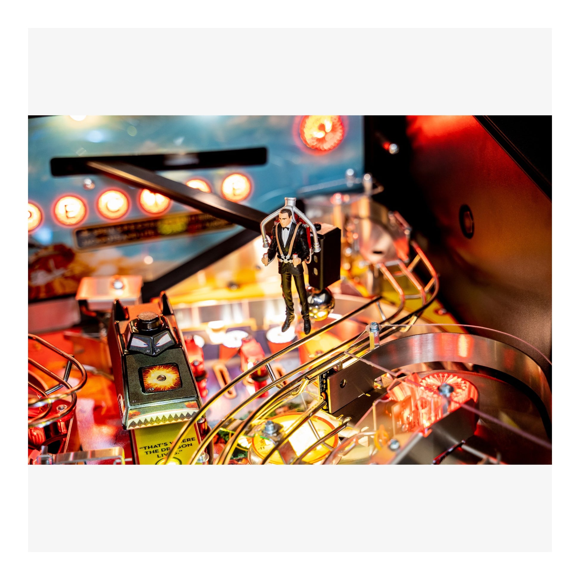 Close-up of a pinball machine with a player figure and lights