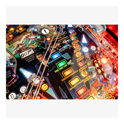 Close-up of a pinball machine with colorful lights and details, featuring a James Bond theme.