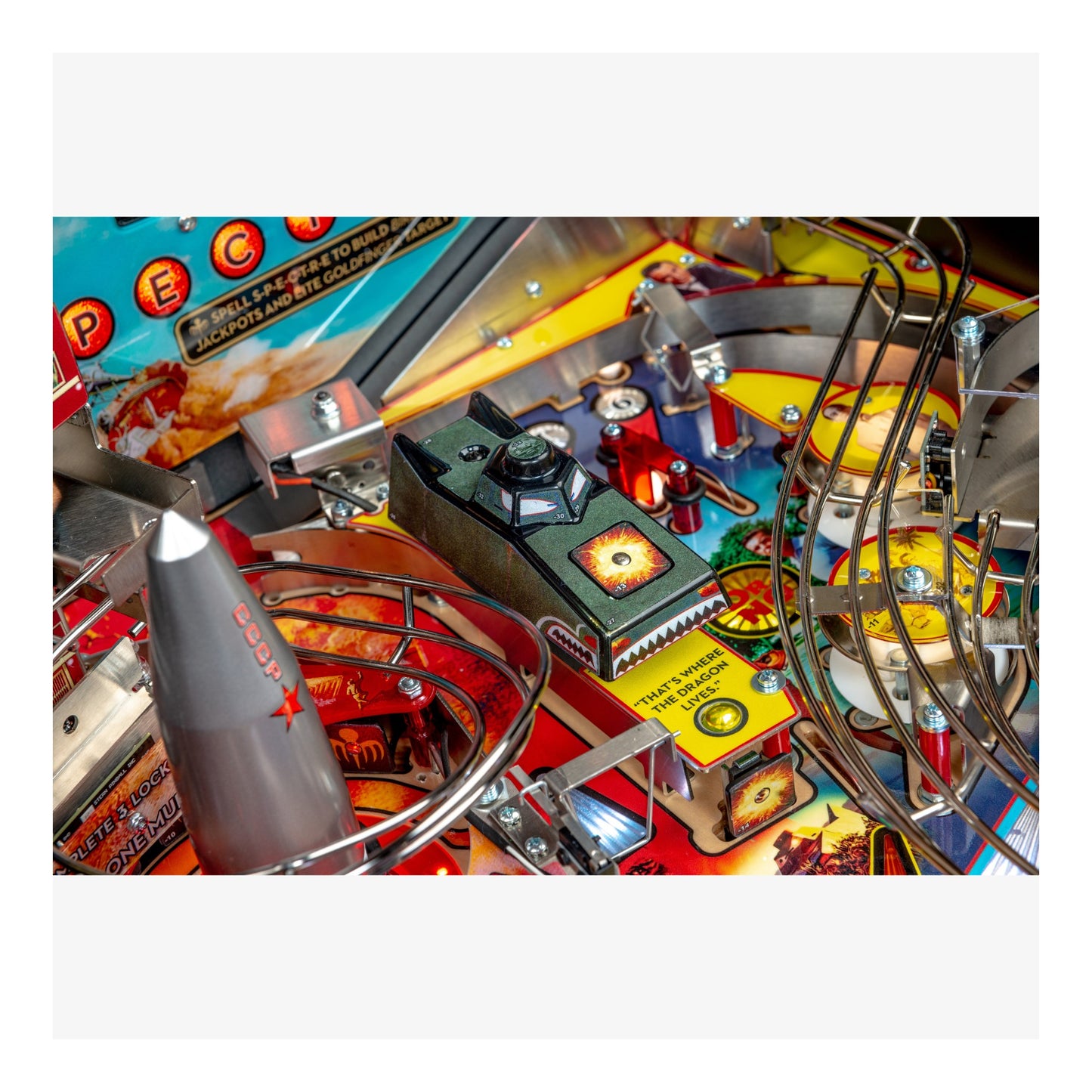Close-up of a pinball machine with colorful playfield and various components.
