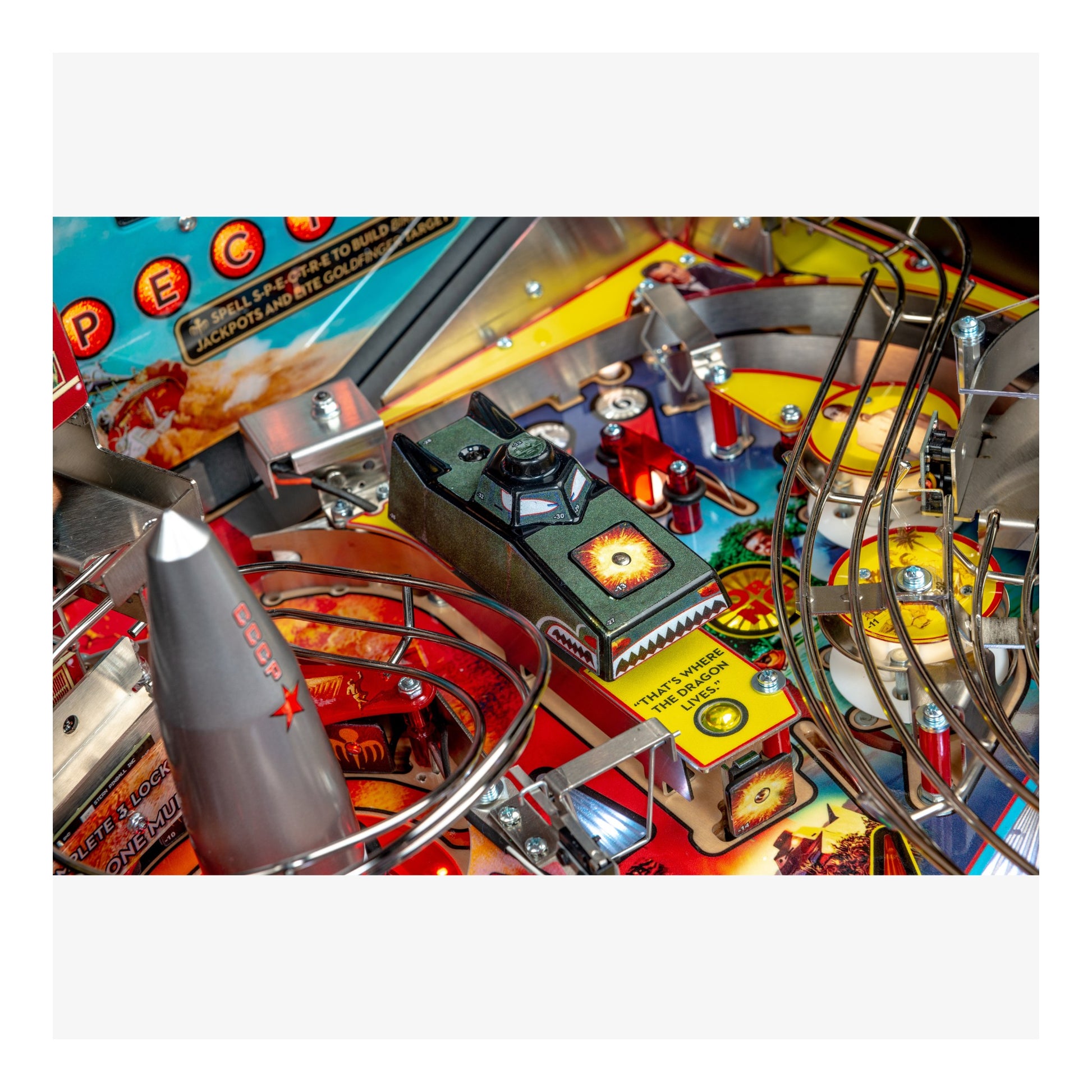 Close-up of a pinball machine with colorful playfield and various components.
