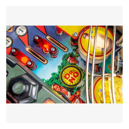 Close-up of a colorful pinball machine with various components and a prominent logo.