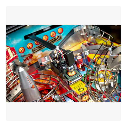 Close-up of a pinball machine with colorful playfield and mechanical components.