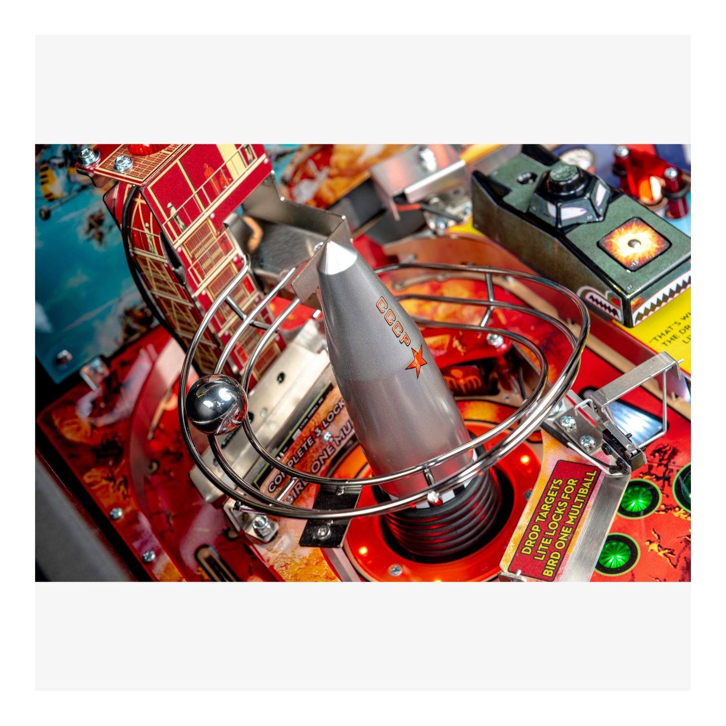 Close-up of a pinball machine's playfield with various components.