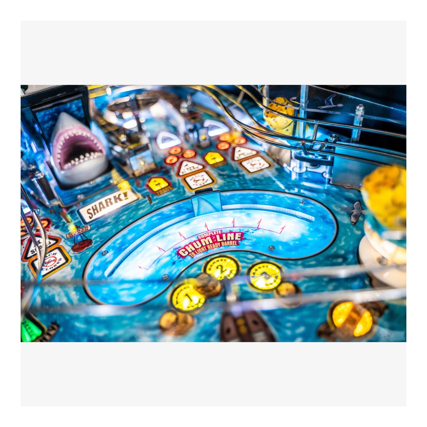 Close-up of a pinball machine with a shark and clownfish design.