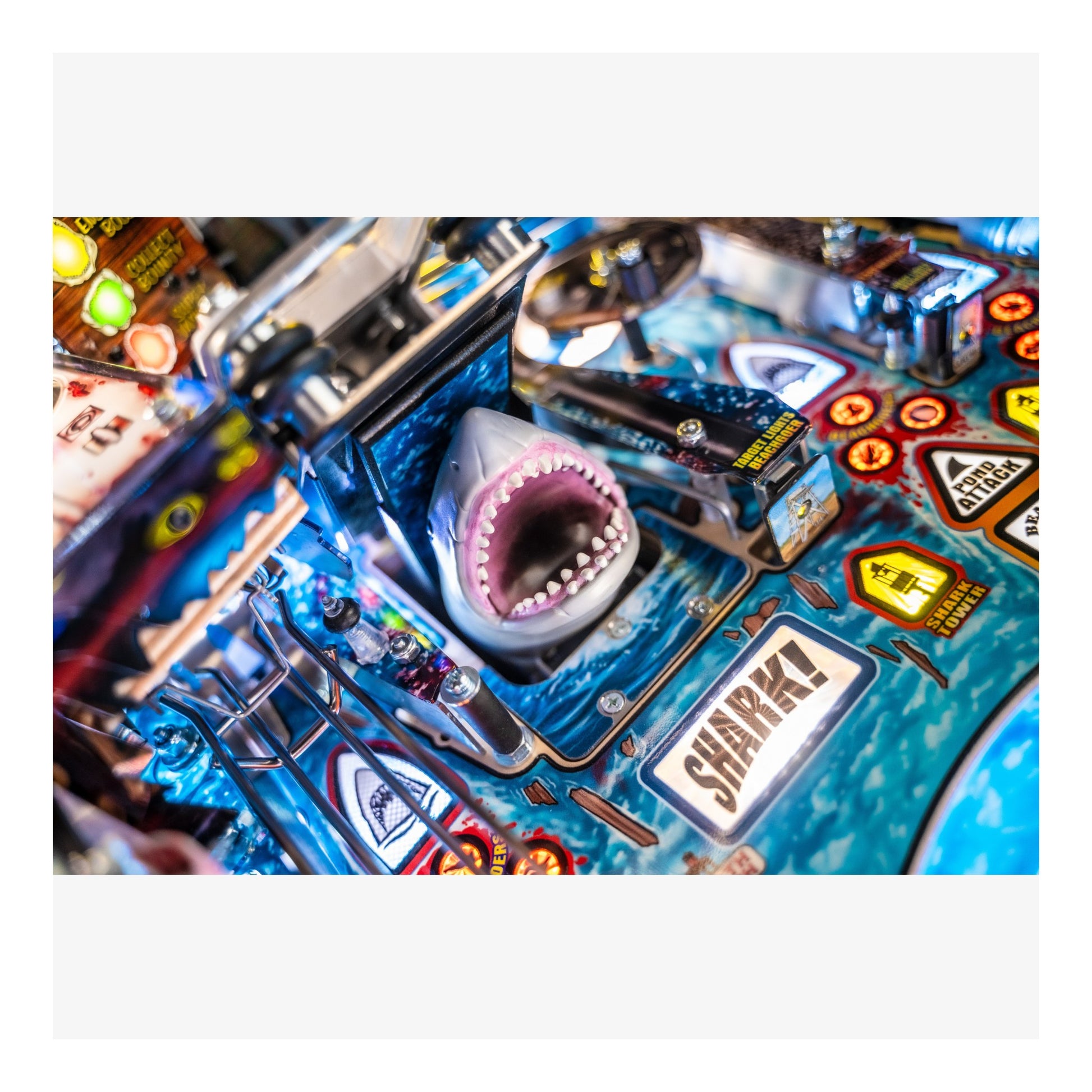 Close-up of a pinball machine with a shark figure and 'Sharky' text.