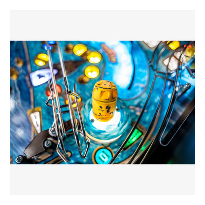 Close-up of a pinball machine with a yellow barrel-shaped object and colorful background