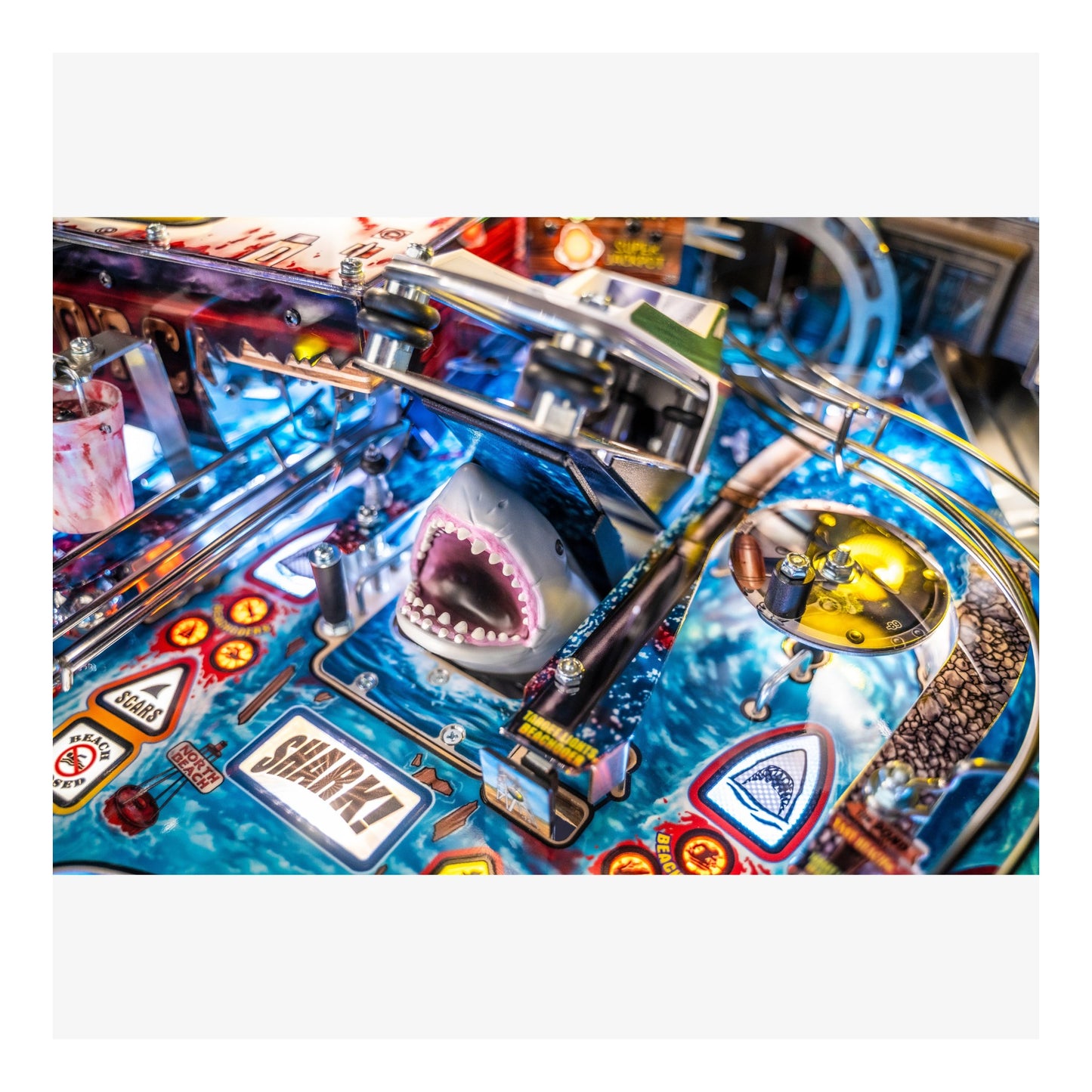 Close-up of a pinball machine with a shark figure and 'Shark!' text.
