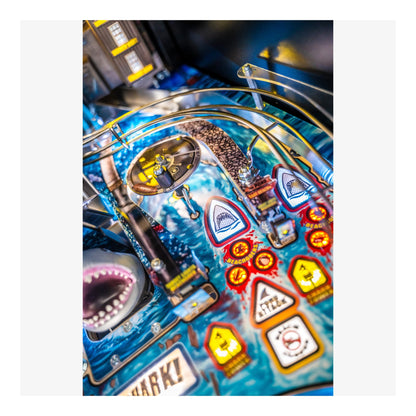Close-up of a pinball machine with colorful artwork and symbols.