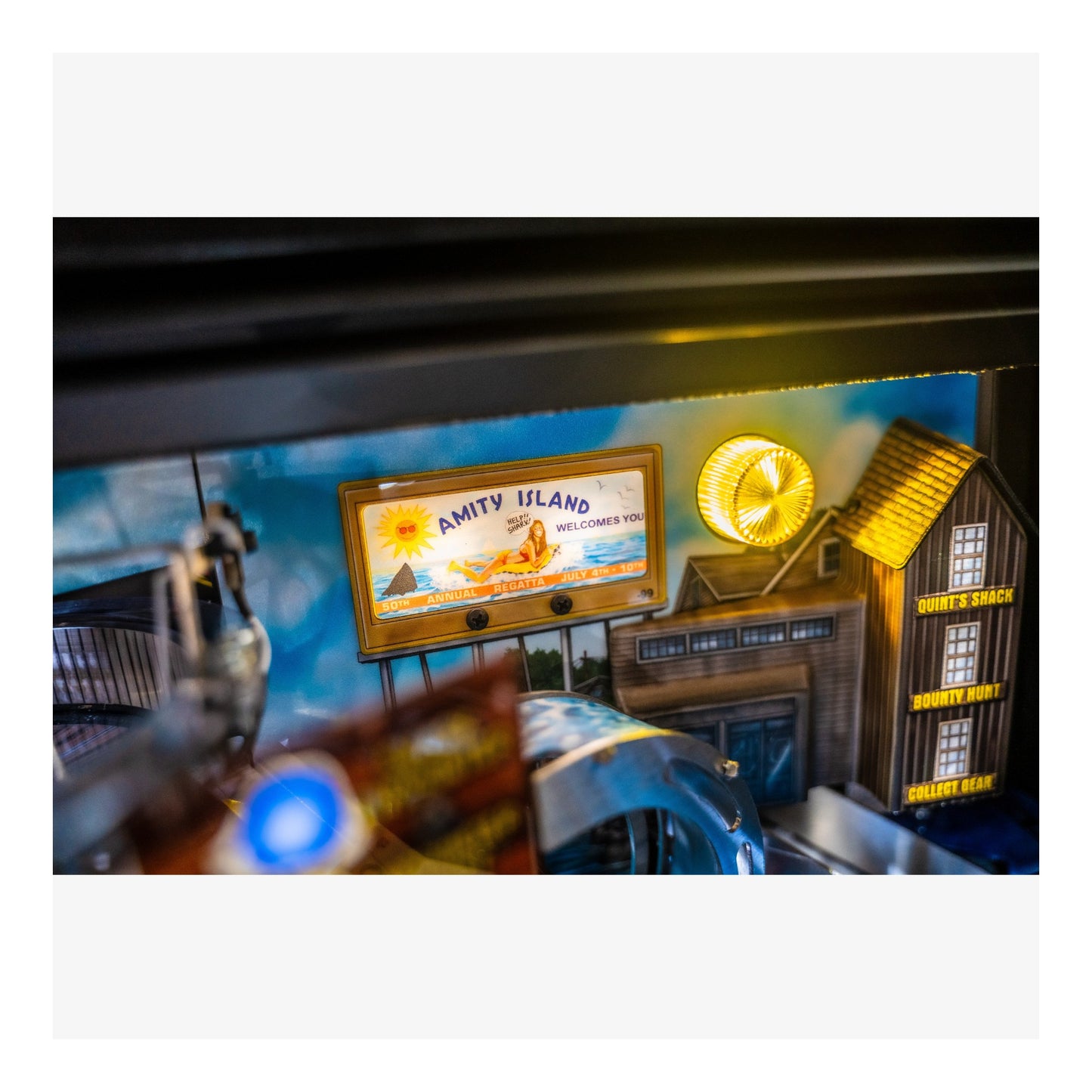 Toy set with 'Amity Island' sign and other miniature objects on a white background