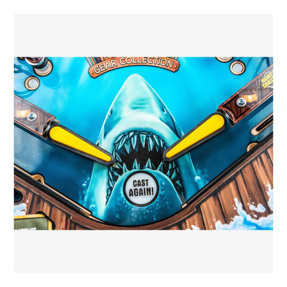 Close-up of a shark-themed pinball machine with a 'Cast Again!' label.