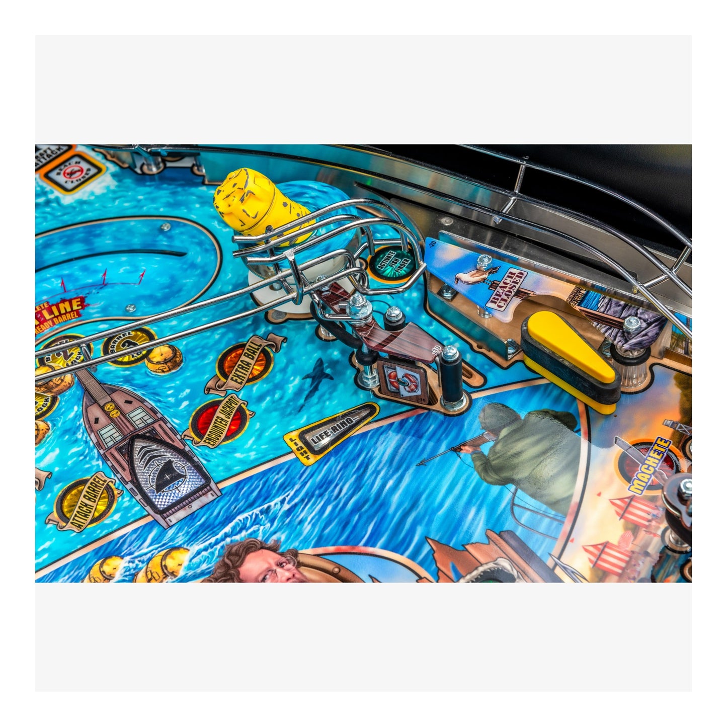 Close-up of a pinball machine with colorful design and various components.