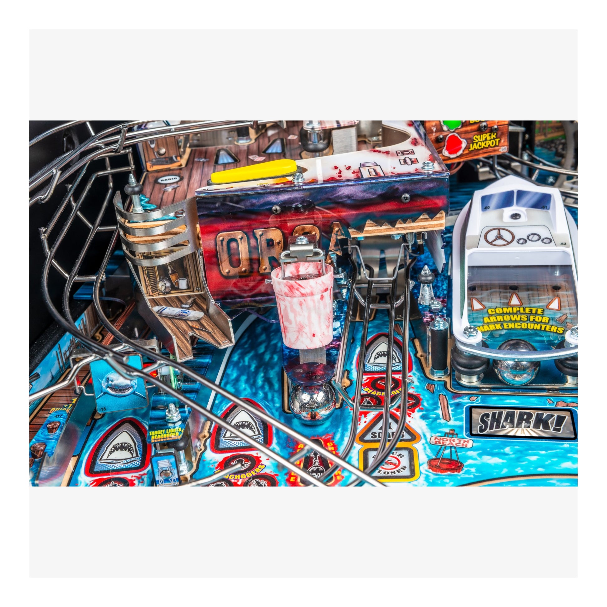 Pinball machine with various elements and a shark figure on a white background