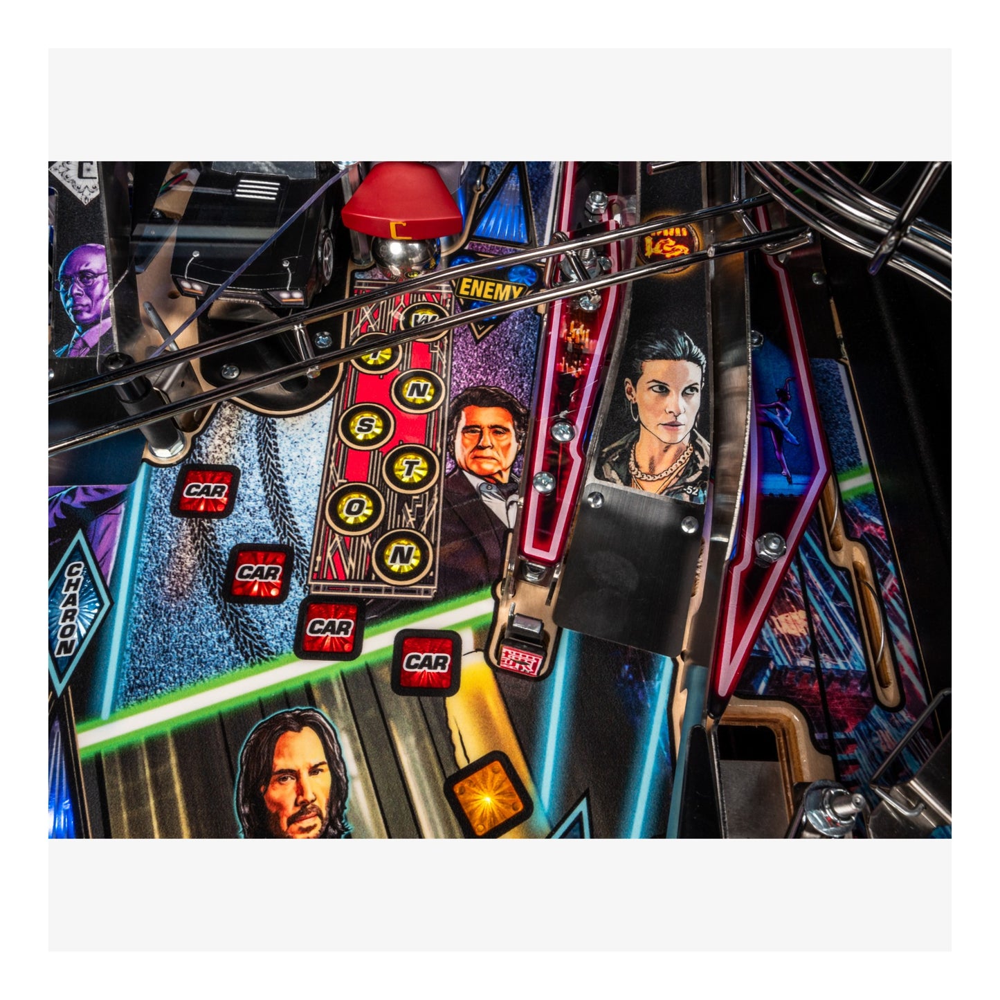 Close-up of a pinball machine with colorful artwork and characters on the playfield.