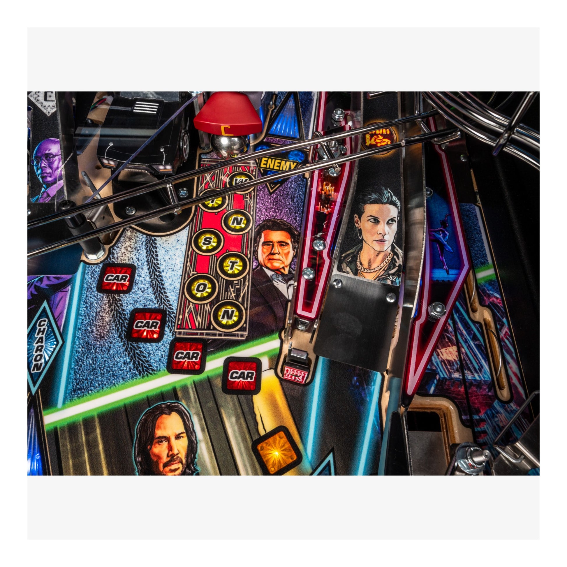 Close-up of a pinball machine with colorful artwork and characters on the playfield.