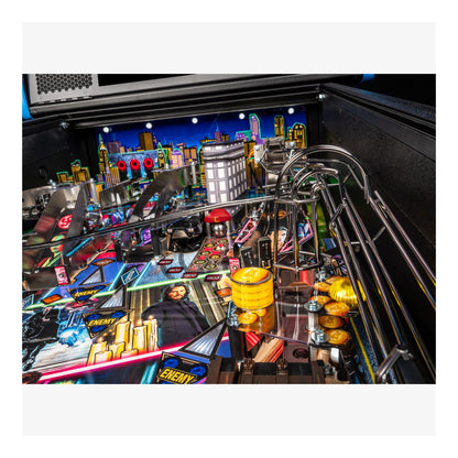 Close-up of a pinball machine with colorful playfield and urban skyline background