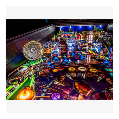 Close-up of a colorful pinball machine with various lights and players' images.